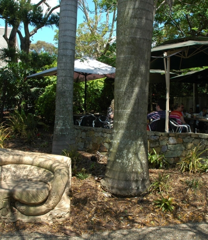 Sandstone scuptures and palm trees surring tables and chairs outside Wordsmith's cafe