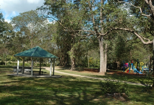 Picnic shelter and kinds plaground inside Bowman Park in Bardon