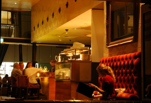 Woman reading a menu in window of Cru Bar in Brisbane's Fortitude Valley at night