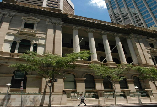 Man walking in front of National Australia Bank building in Brisbane