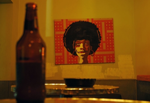 Bottle of beer on table and painting on wall inside Ric's Bar in Brisbane's Fortitude Valley