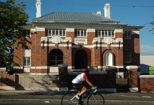 Cyclist riding past Toonarbin house in Highgate Hill