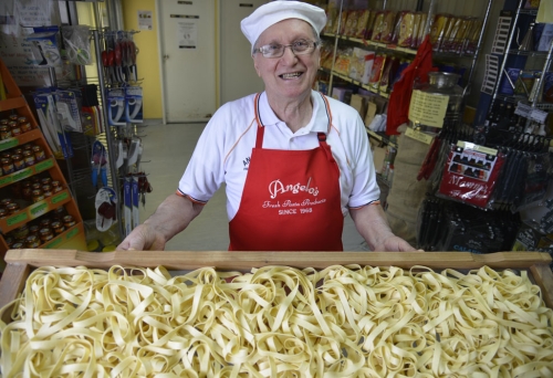 Angelo holding tray of fresh pasta.
