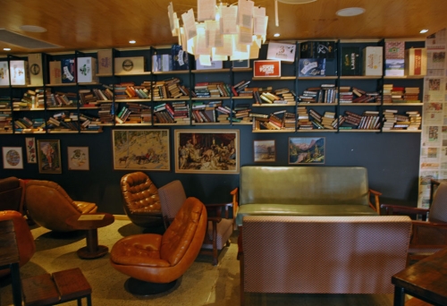 Leather chairs and books on shelves inside Archive Beer Boutique bar in Brisbane's West End