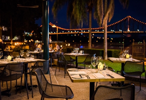 Courtyard dining at Patina Restaurant Customs House Brisbane at night with the Story Bridge in the background