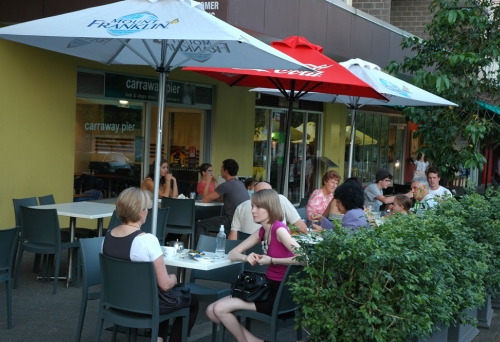 People eating fish and chips outside Carraway Pier Fish & Chips, Kelvin Grove