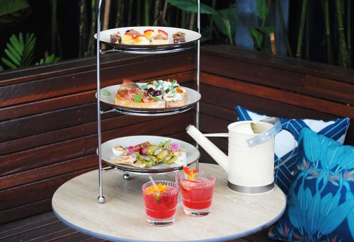 Three tiered plates of gin & tonic high tea with two G&Ts in glasses next to it