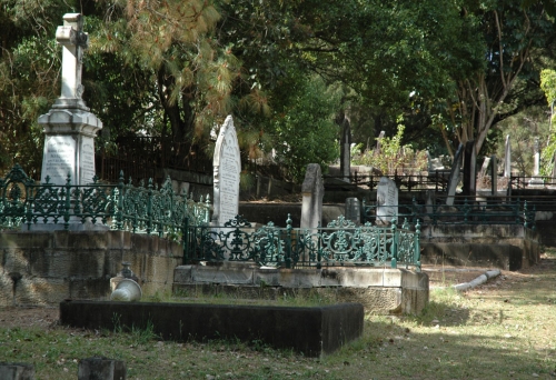 Tomb stones surrounded by bush in Dutton Park Cemetery 