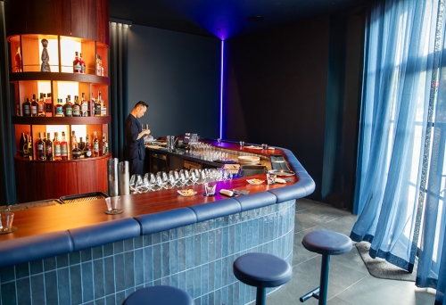 Bartenders standing behind bar in +81 Aziome Bar