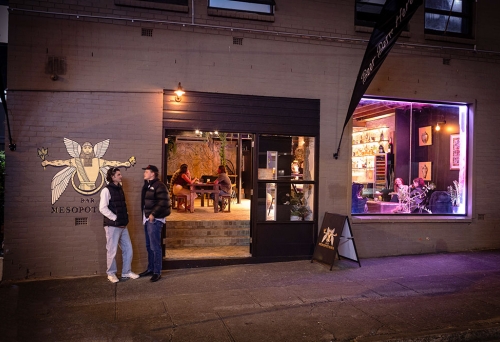 People outside Bar Mesopotamia by night
