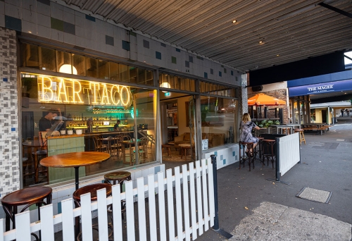 Tables outside and street entry of Bar Taco