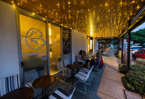 People sitting on tables outside Barrels & Stills Woolloongabba