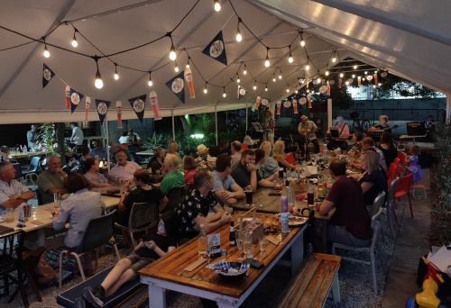 People at long tables in Chill Biergarten Wooloowin