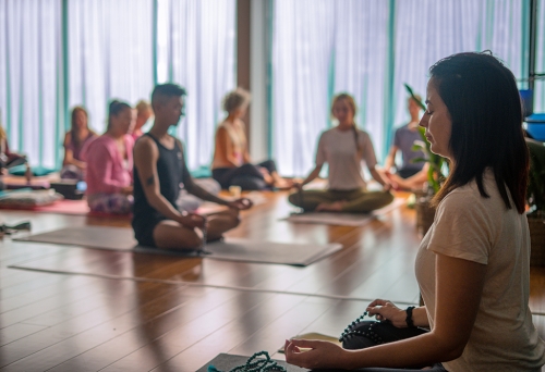 woman leading a group of people meditating