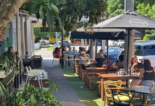 People seated under umbrellas at Double Shot Panini New Farm