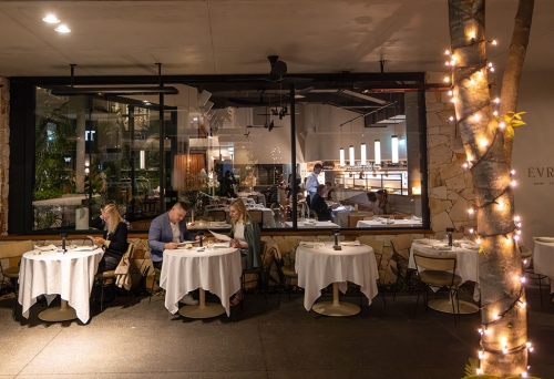 People seated at tables outside Evra Newstead