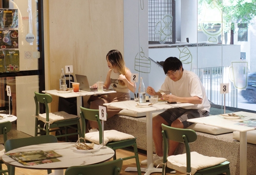 Customers sitting in window of Mitr Dessert House