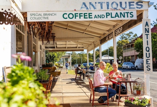 Streetscape of Marburg with a couple sitting at table on footpath
