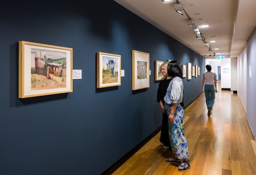 People looking at Cribb Island: Brisbane's Lost Suburb Exhibition at Museum of Brisbane