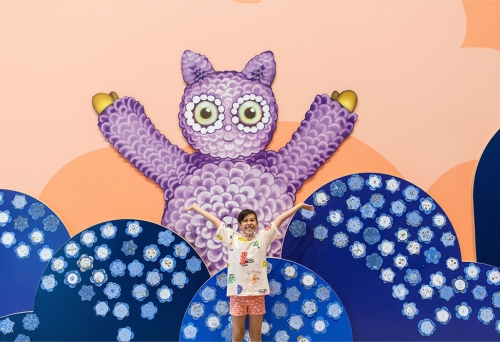 Child standing in front of artwork GOMA