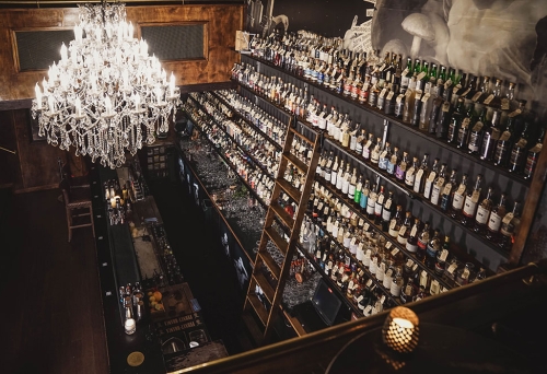 Chandelier and alcohol bottles on walls at Savile Row Fortitude Valley
