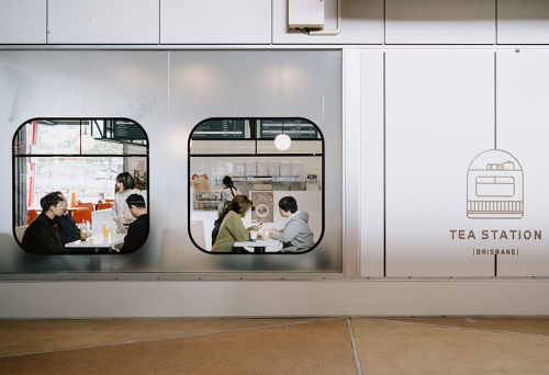 Looking through train-like windows at people dining inside the Tea Station, Eight Mile Plains