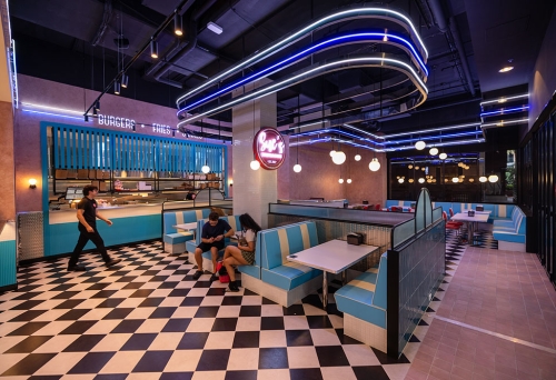 Two people sitting on a booth inside Sue's Burgers and Shakes Woolloongabba