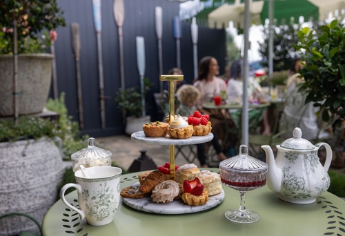 High tea platter with cakes, scones and tea on table in garden at the Tarte High Tea Garden Currumbin 