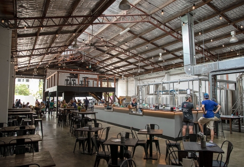 Interior of Sea Legs Brewing with people sitting at tables and standing at the bar