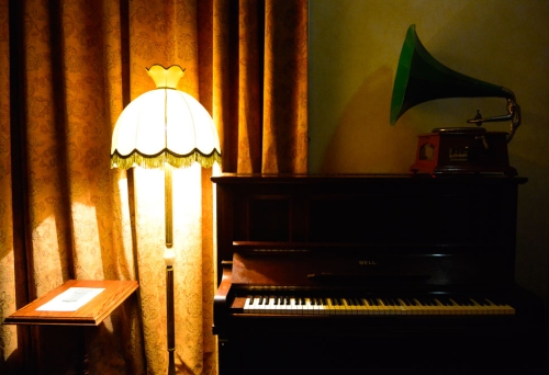 Piano, gramophone and light inside The Gresham Bar dim-lit interior