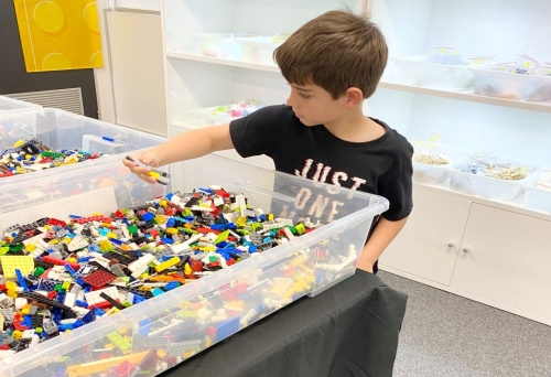 Child picking out LEGOS from box