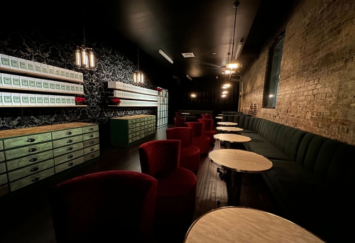 Red chairs and black seating against the wall at night at Red Queen Bar & Gin School Brisbane