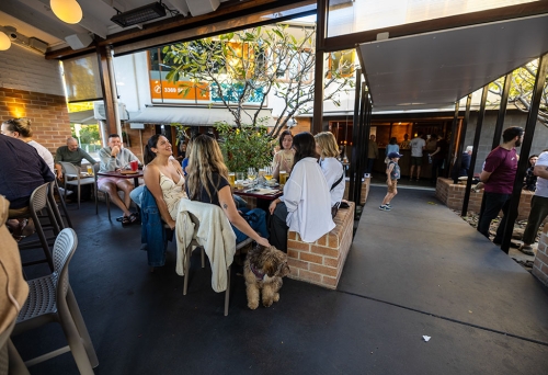 People sitting around a table with a dog at The Patio