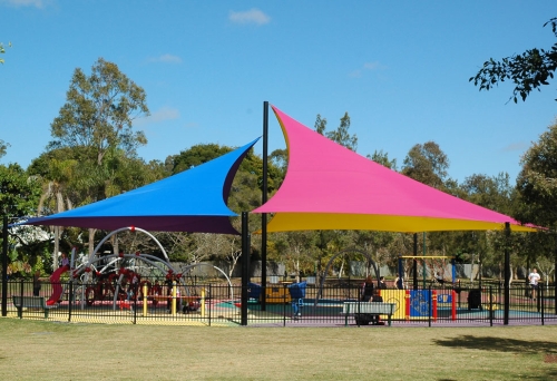Shade sails over fenced playground of Livvi’s Place Playground in Hawthorne Park