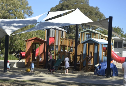 Children playing in fort and on slides inside the Lota Park &amp; Playground in Lota