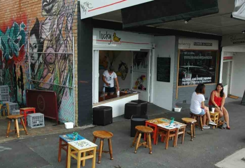 Women sitting on footpath outside Lucky Duck Espresso in Highgate Hill
