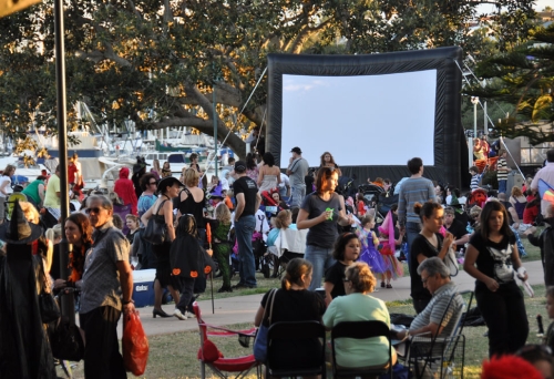 People gathering in front of a screen to watch Movies In The Park, Manly