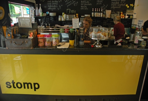 Stomps yellow counter with barista making coffee