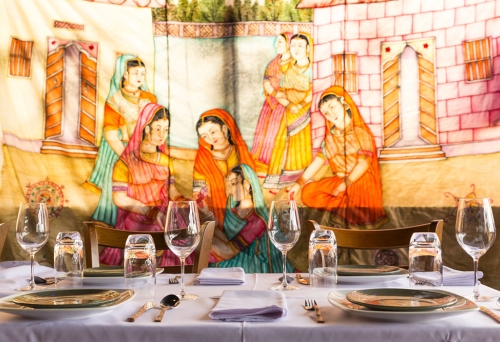 Table set for dinner at It's Mirchi Paddington with mural on wall in background