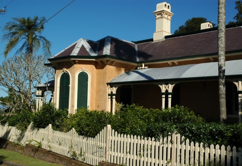 Wilston House behind white picket fence and yard. 