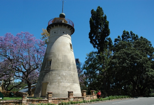 Windmill Tower on Wickham Tce Brisbane at sunrise next to jacaranda tree in full bloom.