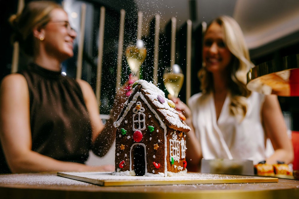 Women with champagne and gingerbread house