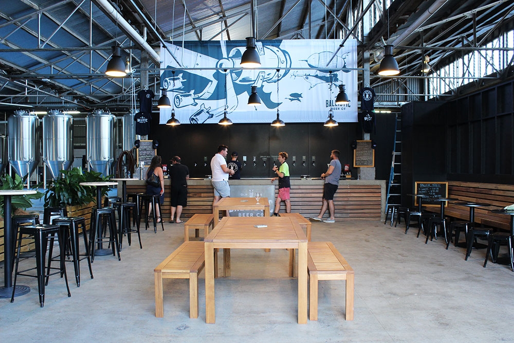 Bench seating and people standing at the bar at Ballistic Beer Co Salisbury