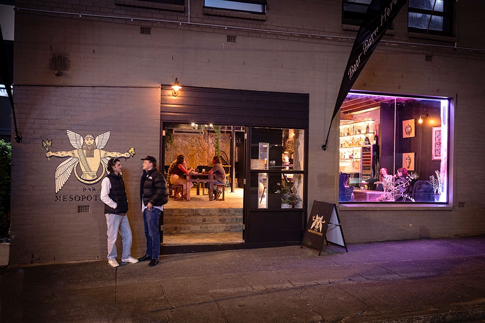 People outside Bar Mesopotamia by night