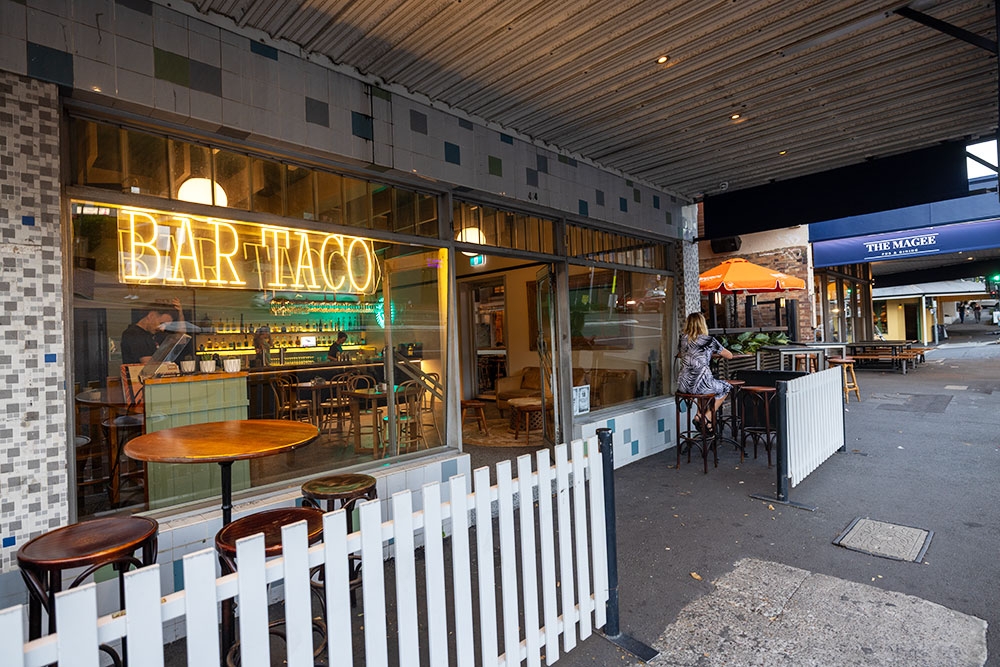 Tables outside and street entry of Bar Taco