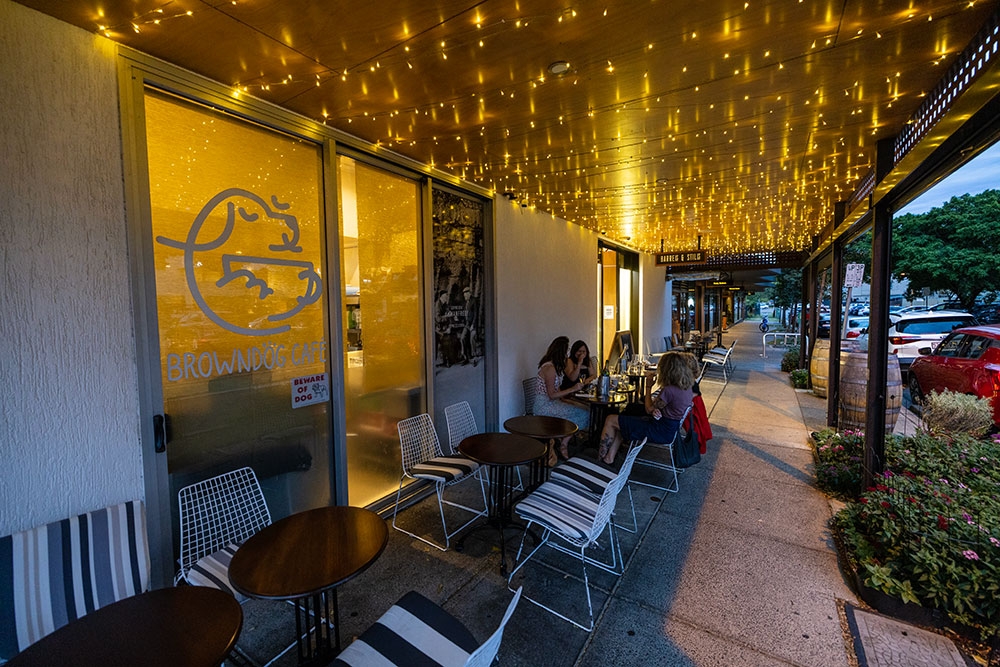 People sitting on tables outside Barrels & Stills Woolloongabba
