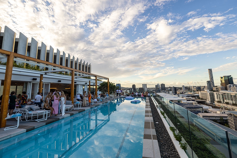 Pool with people siting on Lina Rooftop, South Brisbane 