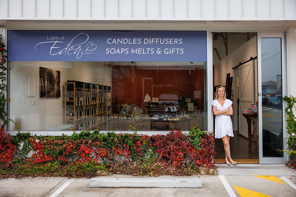 Woman standing outside Lights of Eden home fragrance and gift shop, Albion