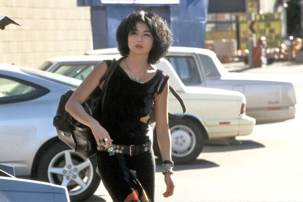 Woman walking next to cars in Maggie Cheung Clean 2004 at the GOMA Hong Kong Cinema