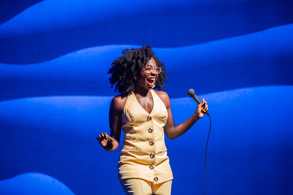 Anisa Nandaula on stage performing her stand up show